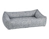 The lakeside urban lounger dog bed has chenille yarn woven together to give a soft raised look to the fabric. It is white and dark blue.