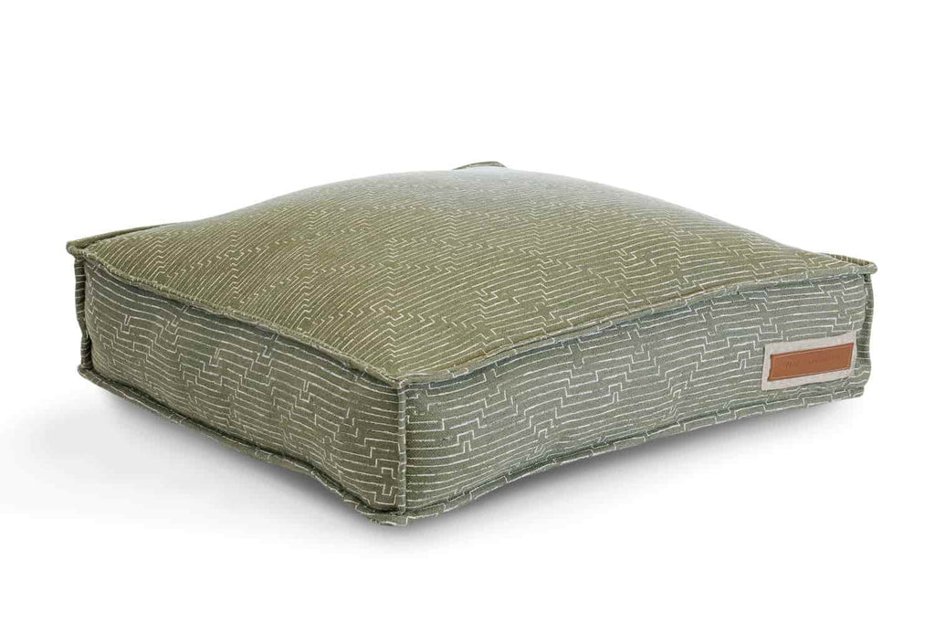 The houndry lounger mossy mutt bed is forest green with white diamond textured lines. The houndry logo leather patch is in the bottom righthand corner 